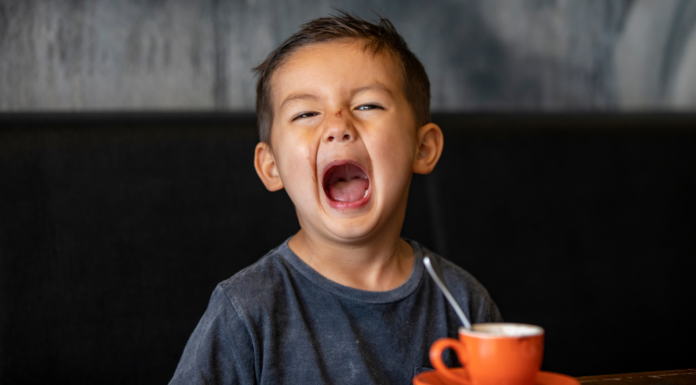 A boy having a tantrum at dinner.
