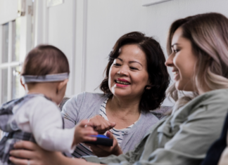 A mother and her mother-in-law holding a baby.