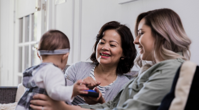 A mother and her mother-in-law holding a baby.