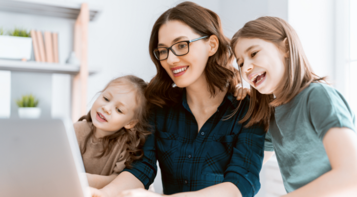 A woman on the computer with her two daughters.