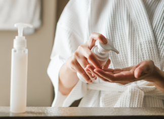 A woman squirting skincare products in her hand.
