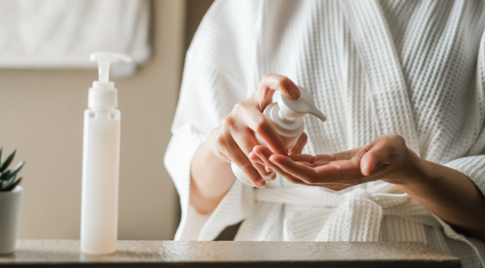 A woman squirting skincare products in her hand.