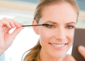 A woman applying mascara.