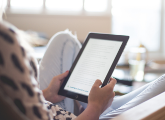 A woman reading on a tablet.