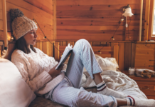 A woman reading cozy in her bed.