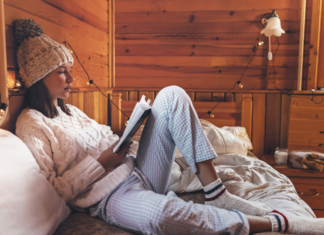 A woman reading cozy in her bed.