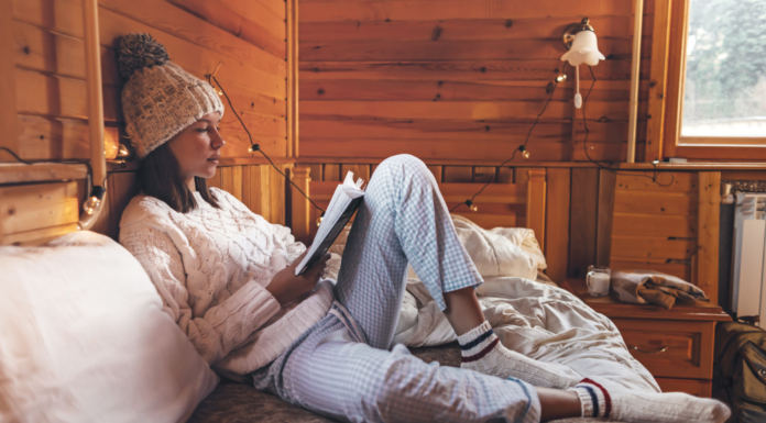 A woman reading cozy in her bed.