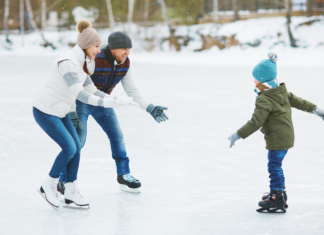 Parents teaching their son how to ice skate.