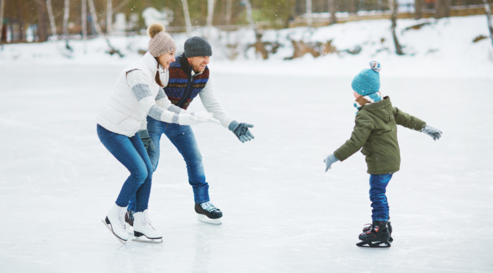 Parents teaching their son how to ice skate.