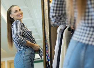 A woman trying on her pre-baby wardrobe.