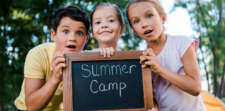 Kids holding a summer camp sign.