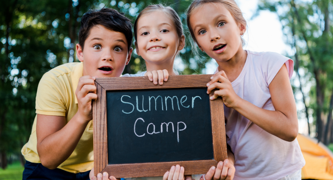 Kids holding a summer camp sign.