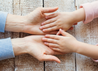 A mom and daughter holding hands.