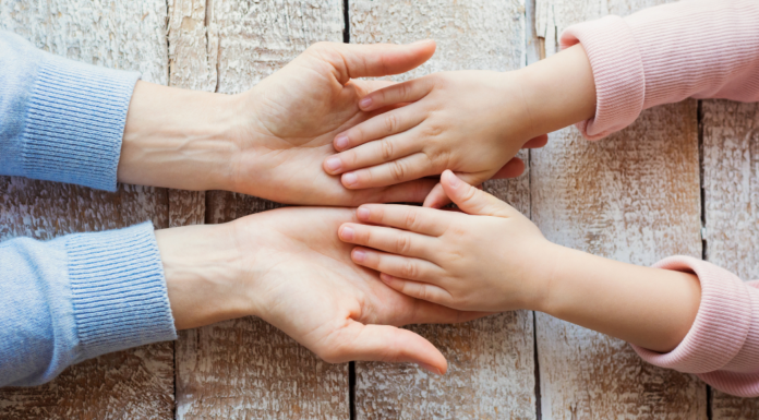A mom and daughter holding hands.