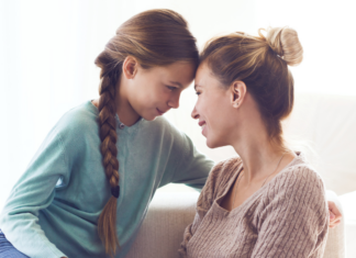 A mom and daughter touching foreheads.