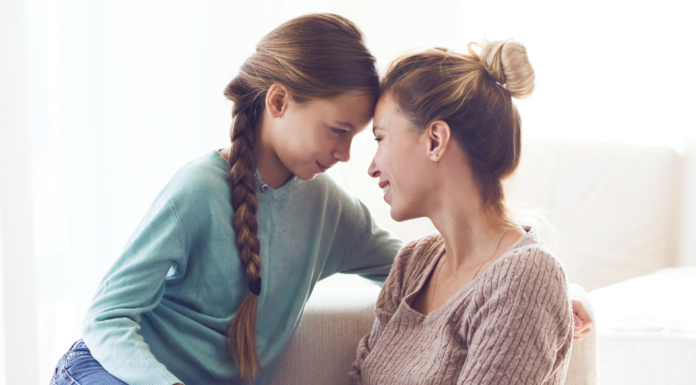 A mom and daughter touching foreheads.