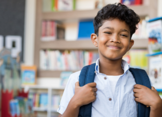 A boy wearing a backpack at school.