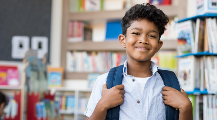 A boy wearing a backpack at school.