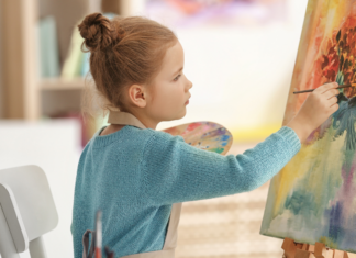 A girl paining on a canvas.