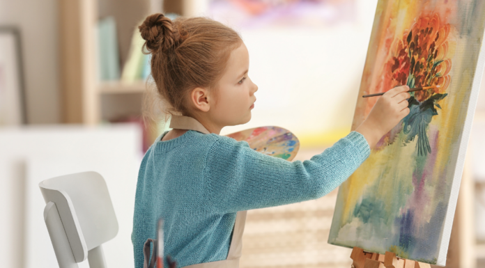 A girl paining on a canvas.