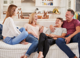 A family hanging out on the couch with older children.