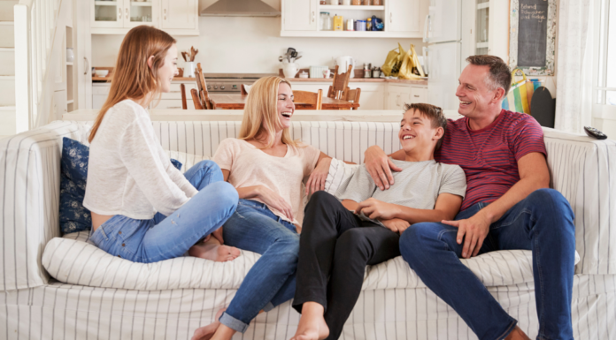 A family hanging out on the couch with older children.