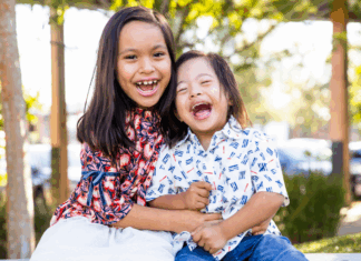The oldest girl holding her brother.