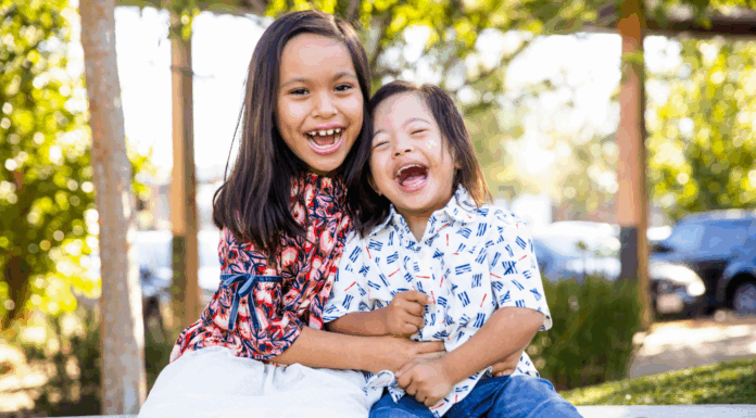 The oldest girl holding her brother.