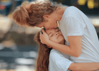 Raising “Haves” When You Grew Up a “Have-Not” A mother kissing her daughter.