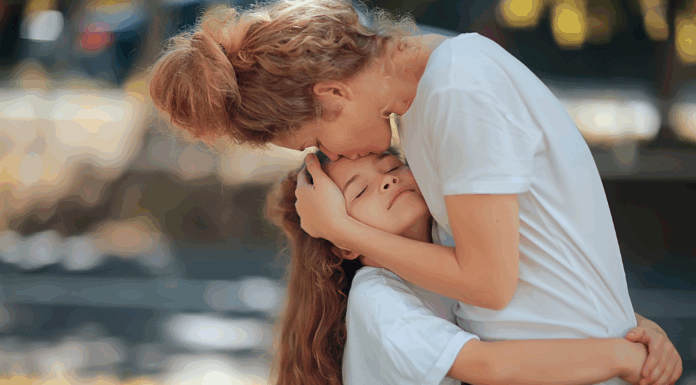 A mother kissing her daughter.