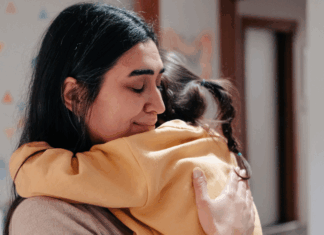 A mom hugging her daughter.