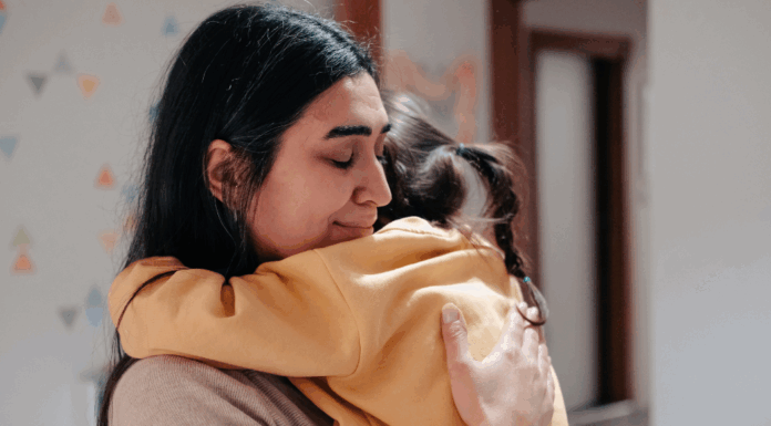 A mom hugging her daughter.