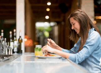 A woman eating at a bar alone.
