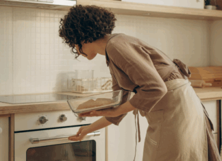 A woman putting fresh bread in the oven.