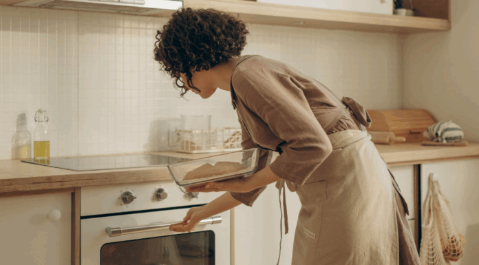 A woman putting fresh bread in the oven.