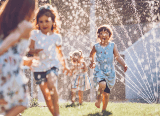 Kids playing in the sprinkler.
