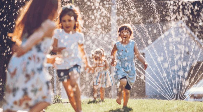 Kids playing in the sprinkler.