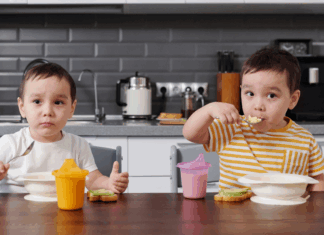 Toddler boys eating breakfast.