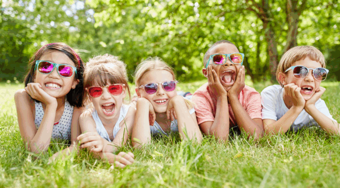 A group of friends wearing sunglasses laying on the grass.