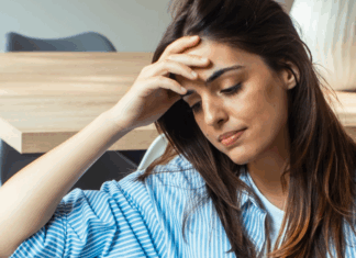A woman struggling with anxiety holding her head.
