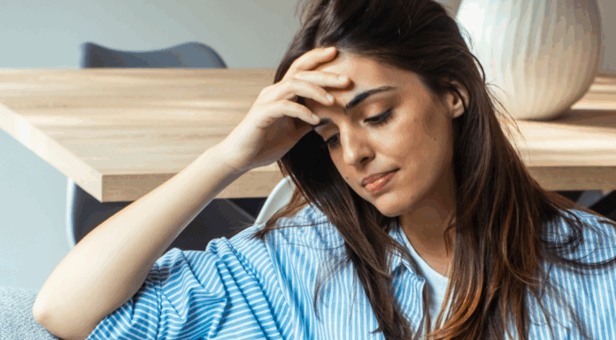 A woman struggling with anxiety holding her head.
