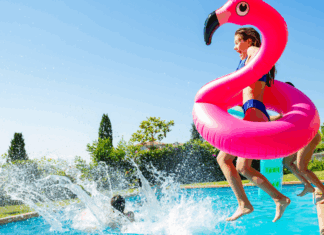 A mom jumping in a pool with her kids.