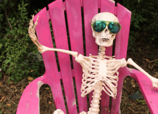 A skeleton wearing sunglasses in a lounge chair.