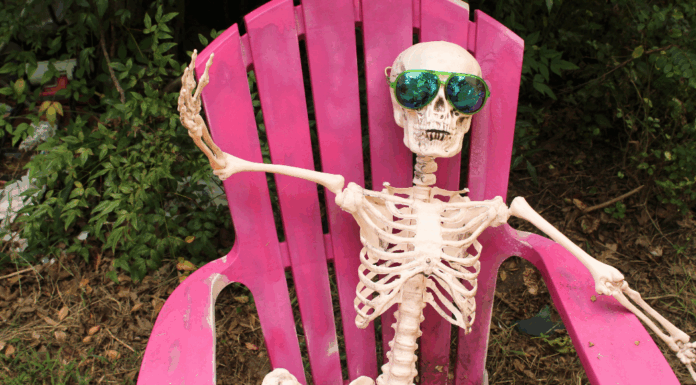 A skeleton wearing sunglasses in a lounge chair.