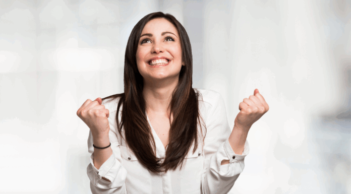 A woman clenching her fists in happiness.
