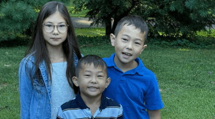 A first day of school photo of three siblings.