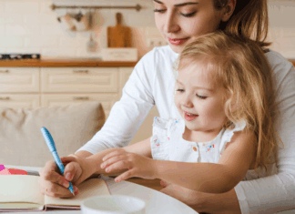 A mom trying to work while holding her daughter.