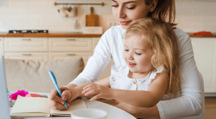 A mom trying to work while holding her daughter.