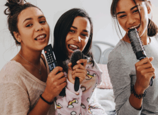 Girls singing into hair brushes.