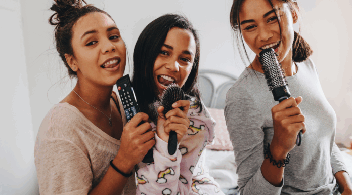 Girls singing into hair brushes.